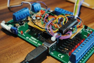 Ročno izdelan vmesnik na prototipnem tiskanem vezju, ki omogoča nadgradnjo 8-bitnega mikrokrmilnika z 32-bitnim (več na: sites.google.com/site/pcusbprojects/4-velleman-experiment-board-k8055-pic-replacement/q-velleman-k8055-to-pic32mx250f128b-adapter-schematic)