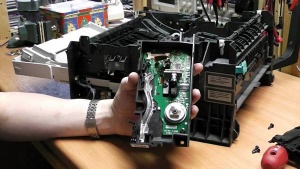 Laserski tiskalnik med popravilom. Na sliki je elektronika z motorjem, ki vrti zrcalo za usmerjanje laserskega žarka.