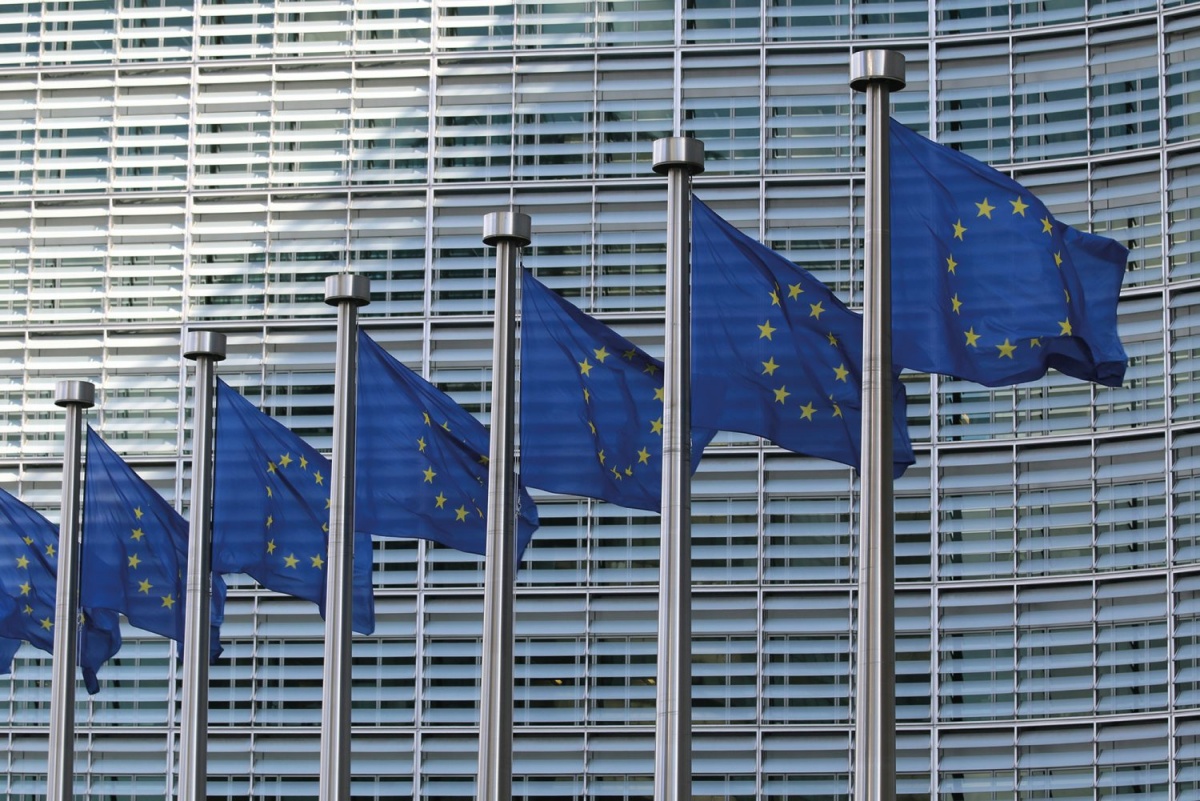 Zastave EU pred Evropsko komisijo v Bruslju simbolizirajo evropsko institucionalno moč, ki pa je zaradi odvisnosti od ZDA omejena na vseh ključnih področjih.